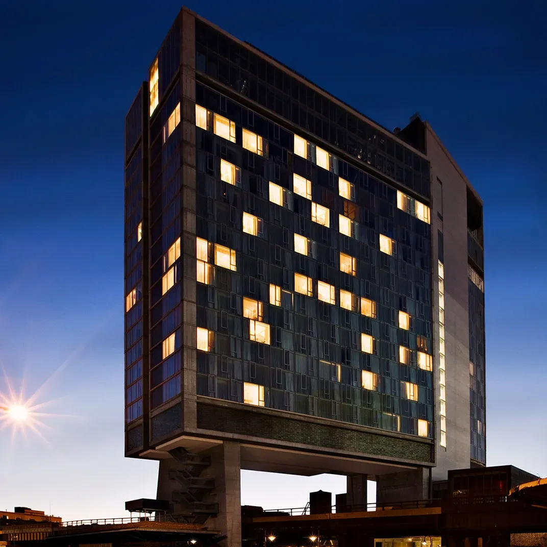 The Standard tower lit over the High Line at dusk